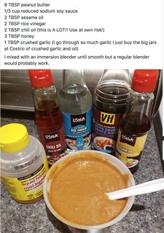 a bowl of peanut butter next to bottles of peanut butter and other condiments