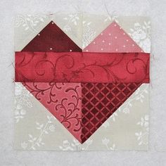 a piece of fabric that has been stitched together with red and pink squares on it