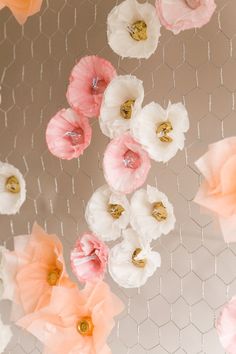 pink and white flowers are hanging from the ceiling in front of a wire mesh net