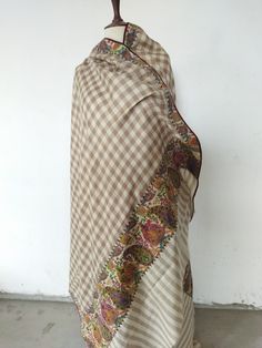 > Semi pashmina, a mix of pure Kashmiri wool and pashmina woven to make the fabric of this shawl > Plain cheque shawl with patch stitched on it > Hand painted and embroidered woollen patch is handstitched over this shawl > Embroidery is in outline > Traditional Kashmiri shawl designs of paisleys, flowers and motifs have been used in these patches > These are patchwork shawls only available at Kashmina > On request, patch can be stitched to any base color of the shawl Luxury Multicolor Katan Silk Pashmina Shawl, Luxury Beige Pashmina Shawl With Dupatta, Multicolor Pashmina Shawl With Embroidered Border, Beige Pashmina Shawl In Traditional Drape, Beige Bohemian Pashmina Shawl, Brown Bohemian Pashmina Dupatta, Bohemian Beige Pashmina Shawl Dupatta, Patchwork Shawl, Shawl Embroidery