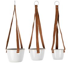 three white pots with brown straps hanging from them