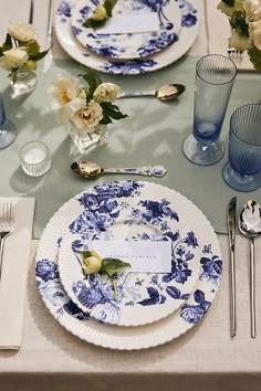 a table set with blue and white plates and silverware