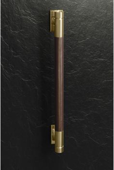 an image of a door handle on a black wall with gold trim and wood accents