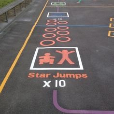 an empty parking lot with various signs painted on the ground and in different colors,