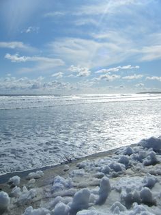 the ocean is covered in snow on a sunny day