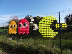 some colorful balloons are hanging on a fence