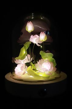 there is a vase with flowers in it on top of a table and the lights are turned on