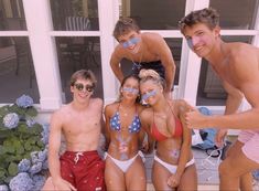 a group of young people standing next to each other in front of a house with face paint on their faces