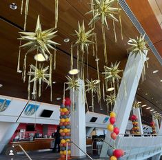 an airport lobby decorated with gold stars and streamers hanging from the ceiling above it