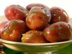 a white bowl filled with red apples on top of a table