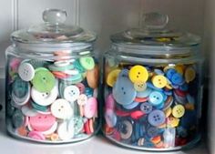 two glass jars filled with different colored buttons