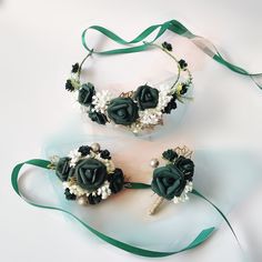 two bridal garters with flowers and pearls on them, one is green