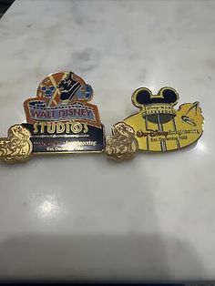 three disney pins sitting on top of a white counter