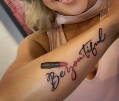 a woman with a tattoo on her arm that says, be brave and lipstick in cursive writing