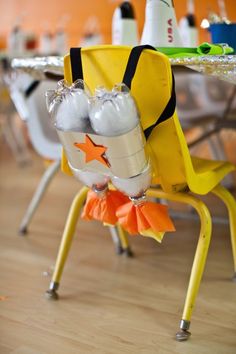 a yellow chair sitting on top of a hard wood floor next to a white table