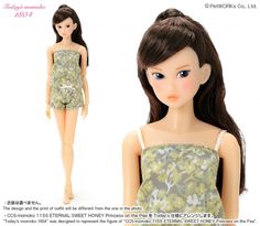 the doll is wearing a green dress with flowers on it's chest and long brown hair