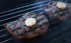 two hamburger patties cooking on the grill