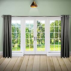 an empty room with french doors and blue curtains