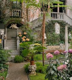 a garden with flowers and plants in front of a building