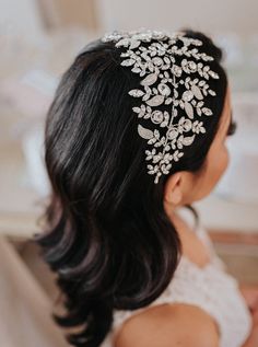 a woman wearing a bridal hair comb with flowers on it's head and pearls in her hair