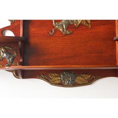 an ornate wooden shelf with metal decorations on it