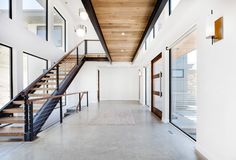 an open floor plan with stairs and windows