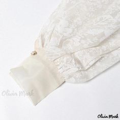 Olivia Mark - Elegant Floral Organza Blouse with Transparent Shawl Collar, Tie Belt, and Lantern Sleeves Elegant Sheer Blouse For Party, Sheer Long Sleeve Blouse For Wedding, Fitted Elegant Beige Blouse Piece, Elegant Sheer Chiffon Blouse, Formal Sheer Chiffon Blouse, Formal White Blouse With Sheer Sleeves, Elegant Long Sleeve Wedding Blouse Piece, Feminine Wedding Blouse With Sheer Sleeves, Elegant Chiffon Blouse For Daywear