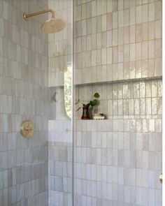 a white tiled bathroom with a shower head