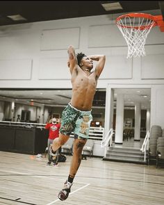 a man jumping up to dunk a basketball into the hoop in an indoor court