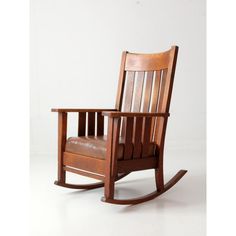 a wooden rocking chair sitting on top of a white floor