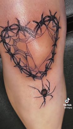 a heart made out of barbed wire on the side of a woman's thigh