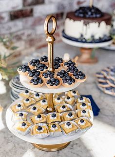 three tiered cake stand with blueberries and pastries on it