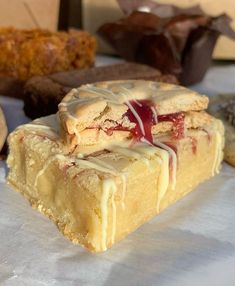 a piece of cake sitting on top of a table next to other desserts and pastries