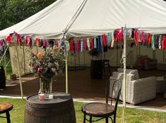 a large tent set up with tables and chairs outside for an outdoor party or event