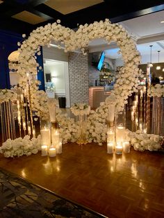 a heart shaped mirror with candles and flowers