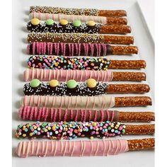 a white plate topped with lots of different types of donuts and sprinkles