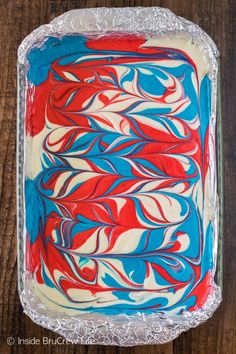 a cake with red, white and blue icing on it sitting on top of a wooden table