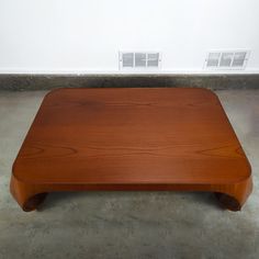 a wooden table sitting on top of a cement floor