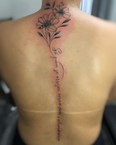 the back of a woman's neck with flowers on it and an inscription written in cursive writing