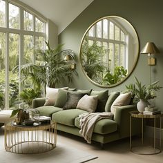 a living room filled with lots of green furniture and large round mirrors on the wall