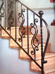 an iron stair railing with wood handrails