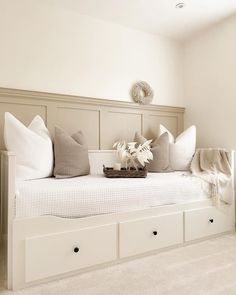 a white daybed with pillows and blankets on it