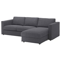 a gray sectional couch sitting on top of a white floor