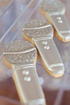 three decorated cookies sitting on top of a plastic container