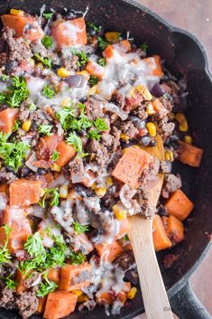 a skillet filled with meat, vegetables and cheese