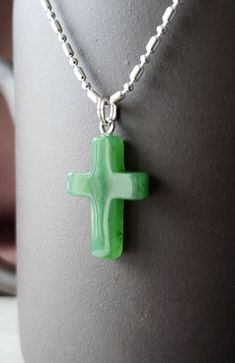 Genuine nephrite jade cross pendant from British Columbia, Canada. The color is a beautiful translucent green. Comes with a plated jump ring. Jade brings harmony and contentment to the wearer. In Asian cultures, Jade is revered as the good luck stone which can bring happiness, wealth, and friendship. Option to purchase heavy solid 925 sterling silver chain necklace. 22mm x 14mm Spiritual Jade Necklace Gift, Green Cross Pendant Necklace As Gift, Green Spiritual Cross Pendant Jewelry, Green Spiritual Necklace As Gift, Spiritual Green Necklace For Gift, Handmade Healing Cross Jewelry, Handmade Green Cross Jewelry, Cross Shaped Natural Stones Jewelry For Gift, Green Cross Necklace For Gift