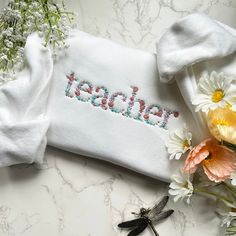 Embroidered Floral Teacher Sweatshirt, Gift for Teacher - Embroidered Items are stitched to order. Please allow 1-2 weeks for items to ship.  - Unisex Crewneck Sweatshirt - Designed with pre-shrunk soft air-jet spun yarn - Loose fit for a comfortable feel * Sizing and Colors - Please refer to sizing and color charts in the images * Fabrication - 50% cotton, 50% polyester * Care Instructions - Turn inside out and machine wash cold on delicate cycle - Dry on low heat setting - Do not bleach - Do n Embroidered White Sweatshirt For Gift, White Embroidered Sweatshirt For Gift, White Embroidered Sweatshirt As Gift, Cotton Sweatshirt With Multicolor Embroidered Text, Multicolor Embroidered Cotton Sweatshirt, Multicolor Letter Embroidery Cotton Sweatshirt, Embroidered Items, Teacher Sweatshirt, End Of School Year