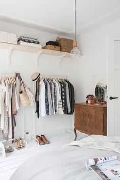 an image of a closet with clothes hanging on the rack and other items in it