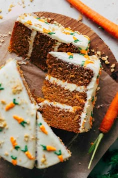 carrot cake with white frosting and green sprinkles on a wooden cutting board