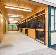 the inside of a horse stable with stalls and stalls on either side of the door